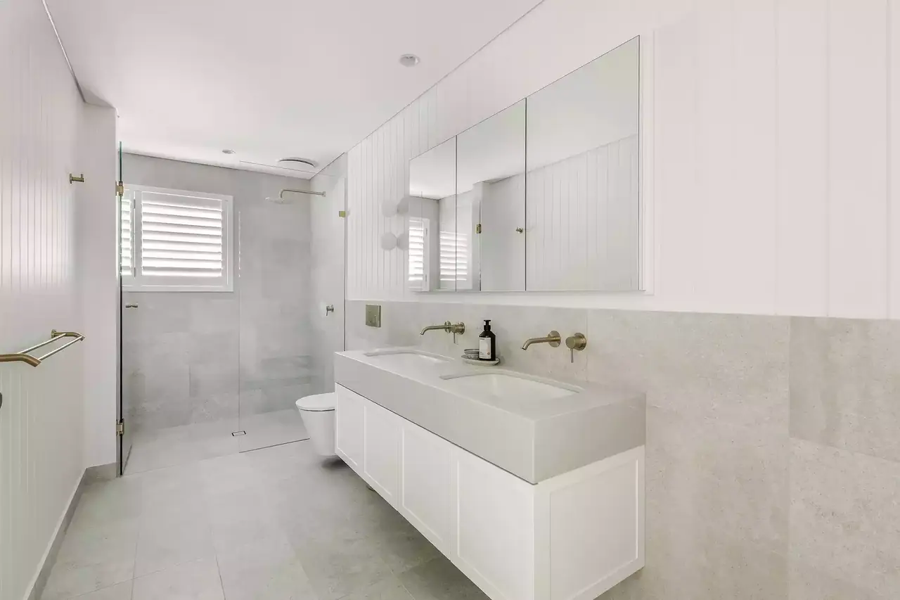 Family bathroom with a white drawer vanity and a mirrored wall cabinet