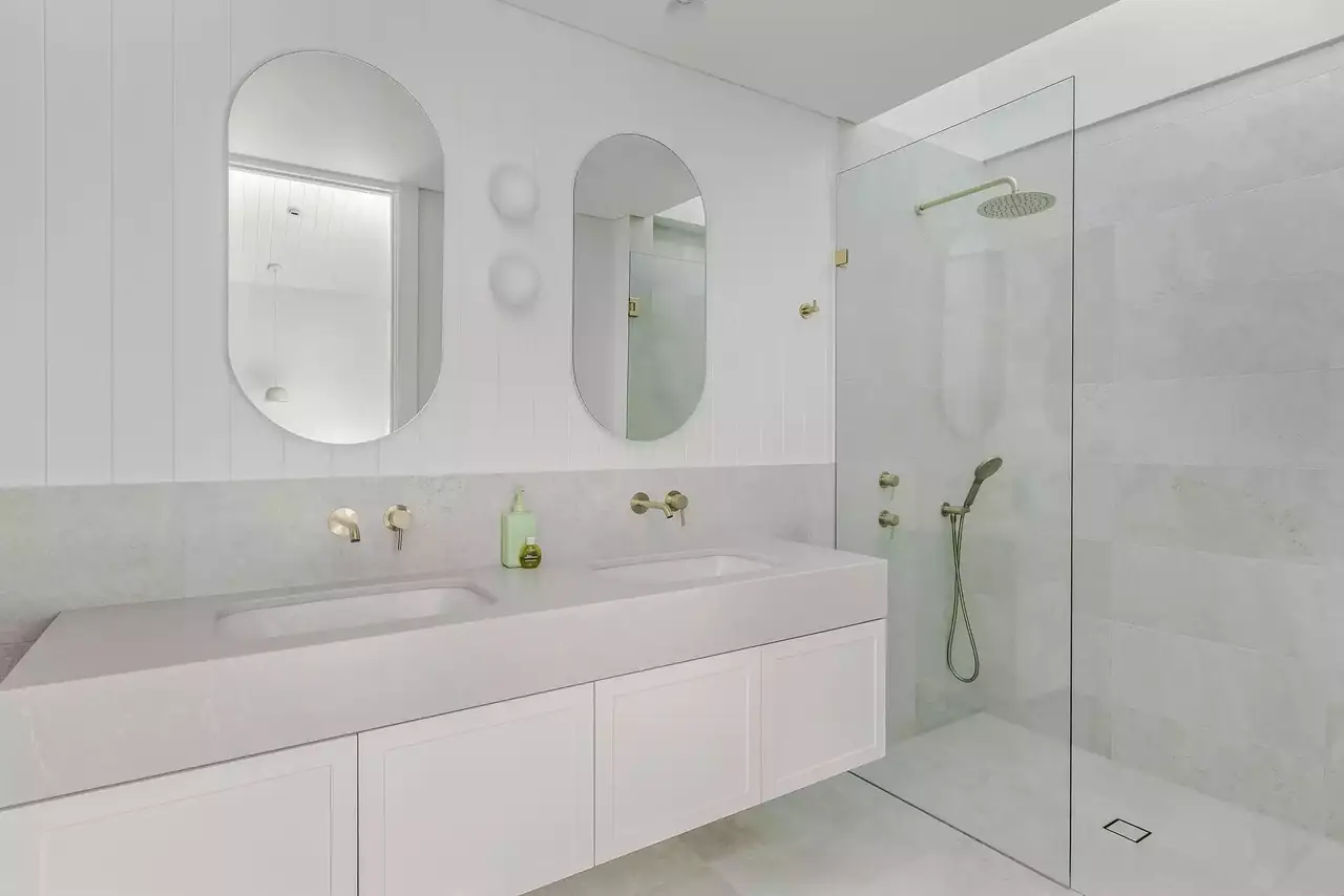 Bathroom with a long white vanity and a walk-in shower