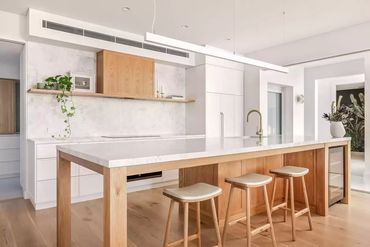 Kitchen with a timber island, white benchtop and timber stools