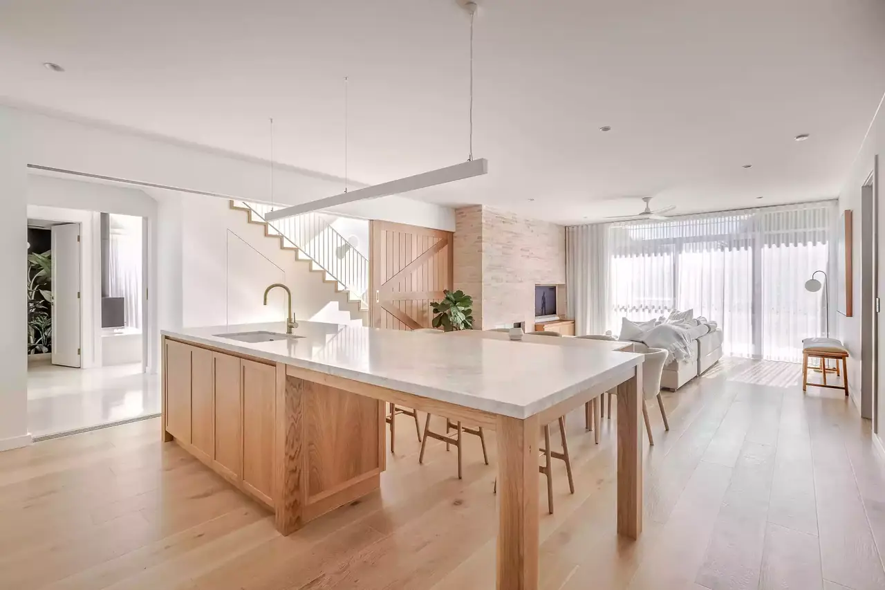 Open-plan kitchen with a timber island beneath a pendant light
