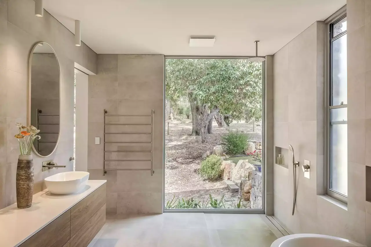 Timber vanity with a vessel basin beside a full-height window